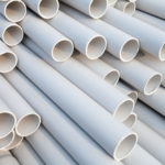 Heap of PVC pipes stacked at construction site, Close-up.